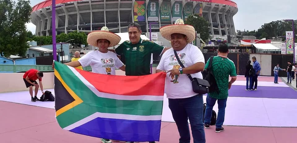 Fanáticos sosteniendo bandera de Sudáfrica en estadio