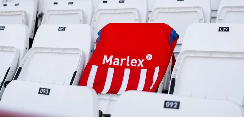 Camisa roja con rayas en asiento vacío del estadio