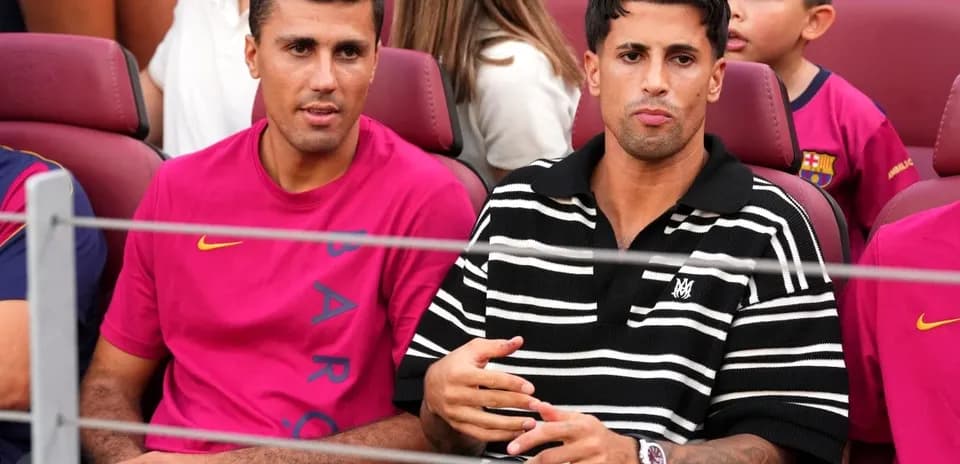 Dos hombres sentados en un estadio de fútbol