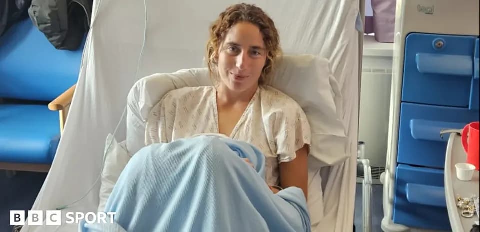 Atleta sentada en cama de hospital con manta