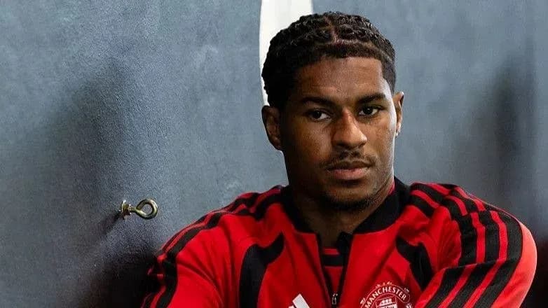 Jugador sentado en el vestuario con uniforme rojo
