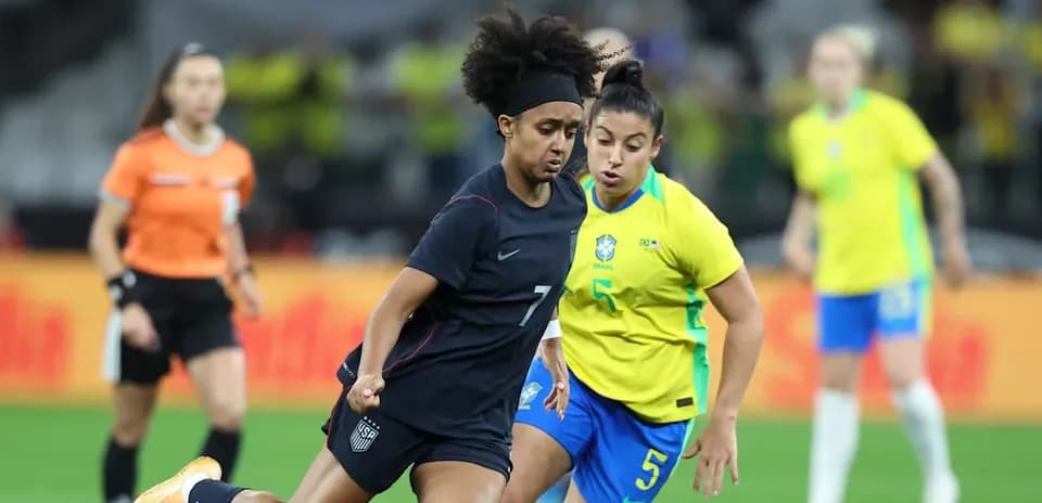 Jugadora de Estados Unidos y Brasil compitiendo por el balón