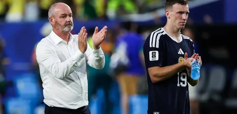 Entrenador aplaudiendo junto a jugador en el campo
