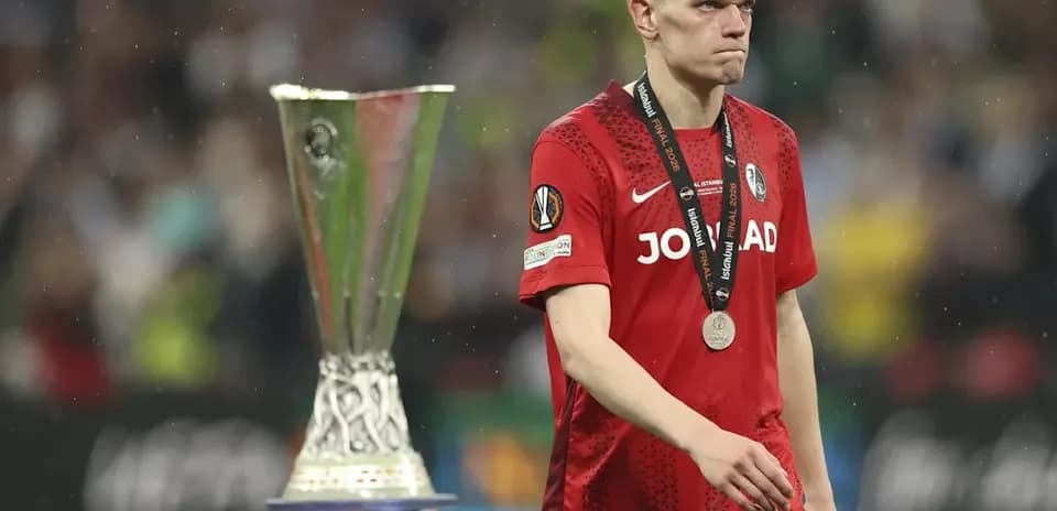 Jugador caminando junto al trofeo de la Europa League
