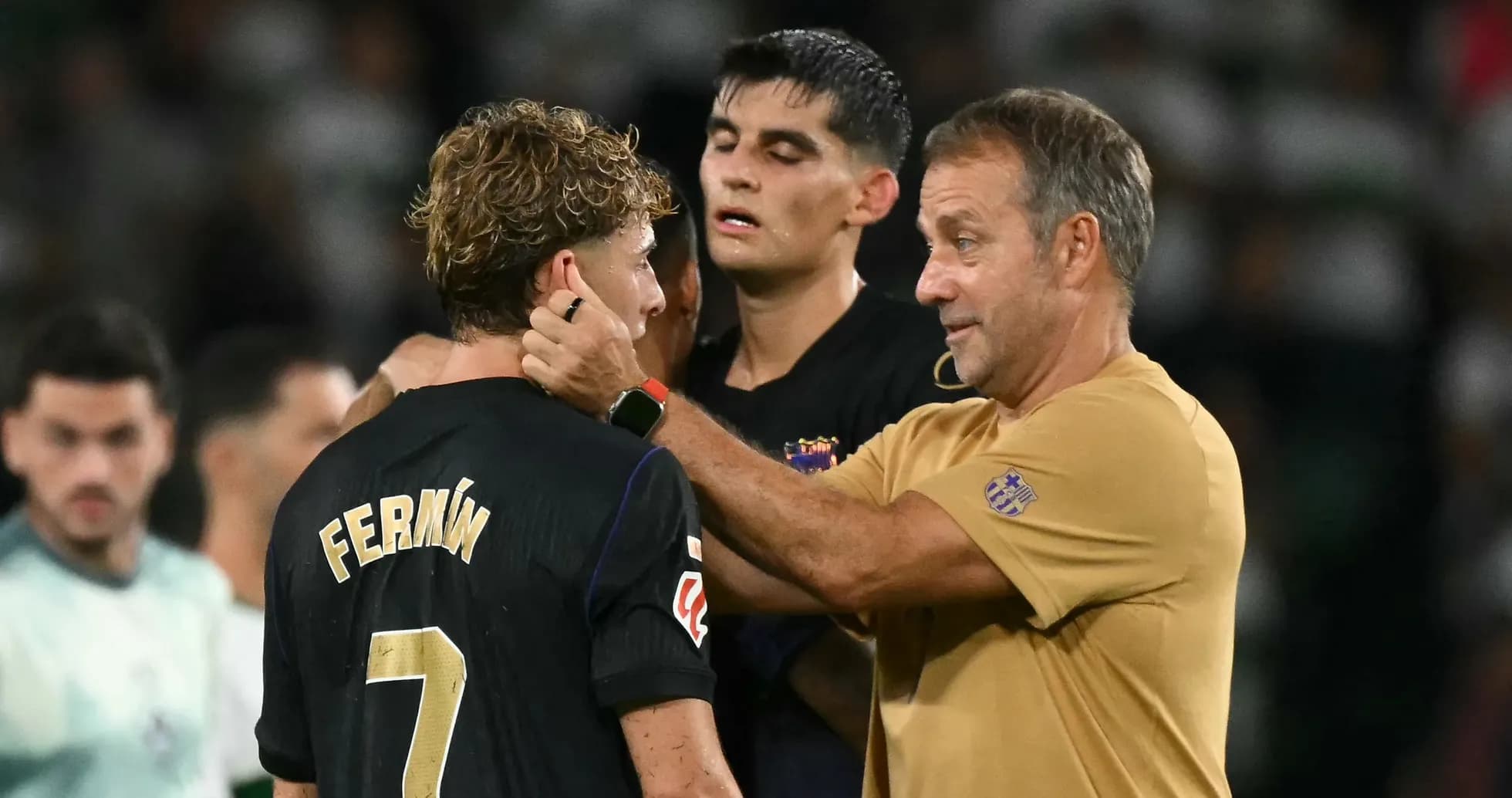 Entrenador hablando con jugador Fermín en el campo