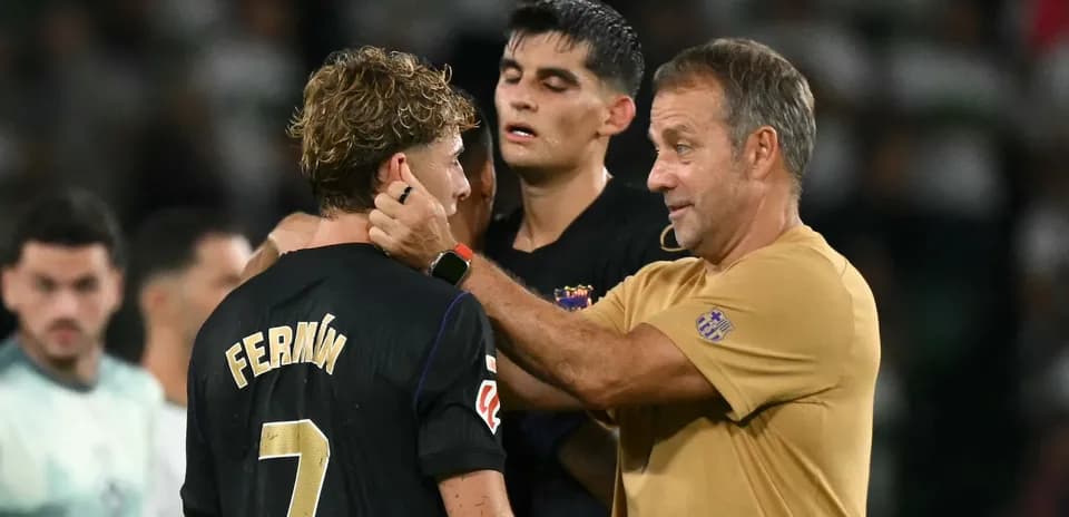 Entrenador hablando con jugador Fermín en el campo