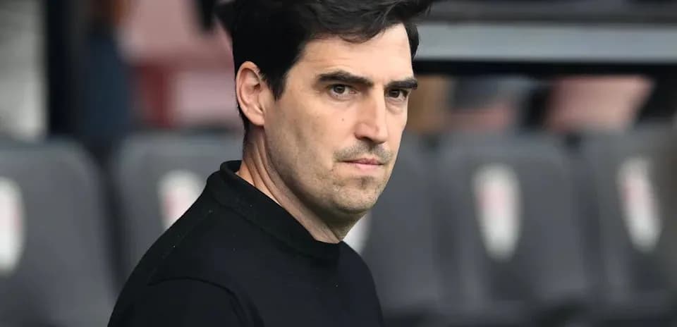 Entrenador observando desde el banquillo del estadio