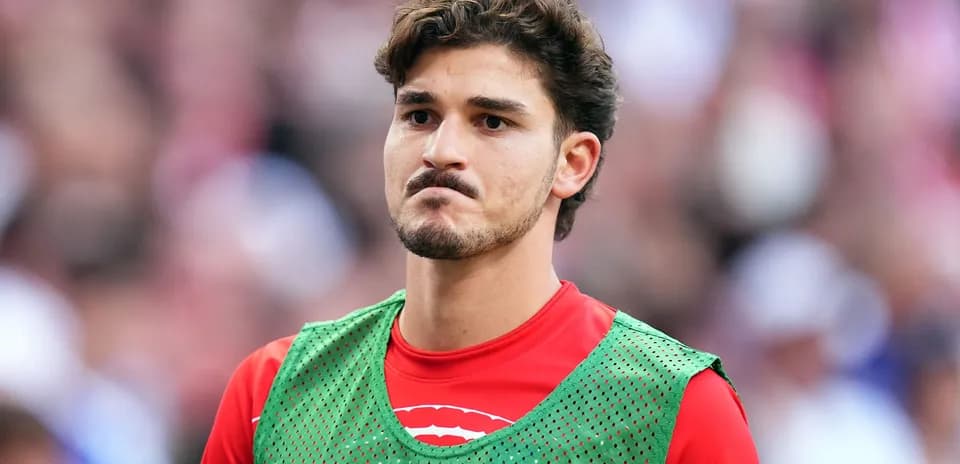 Jugador en el banquillo con chaleco de entrenamiento
