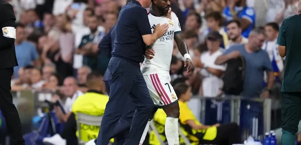 Entrenador saludando a jugador del Real Madrid en partido