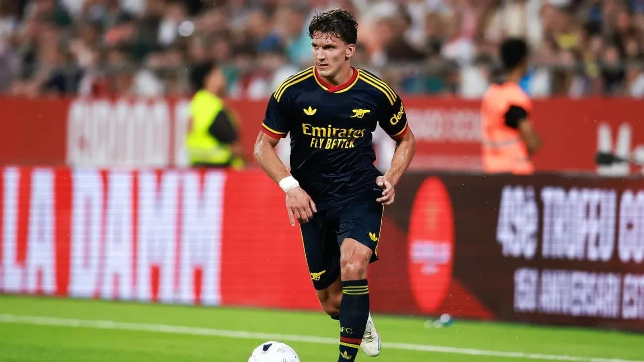 Jugador de Arsenal corriendo con el balón en el campo