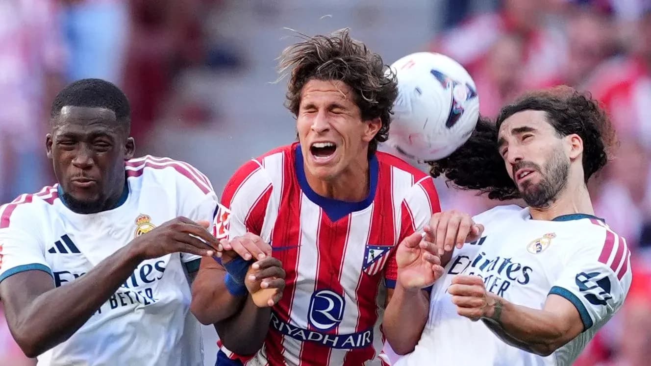 Jugadores de Atlético y Real luchando por el balón Jugadores de Atlético y Real luchando por el balón