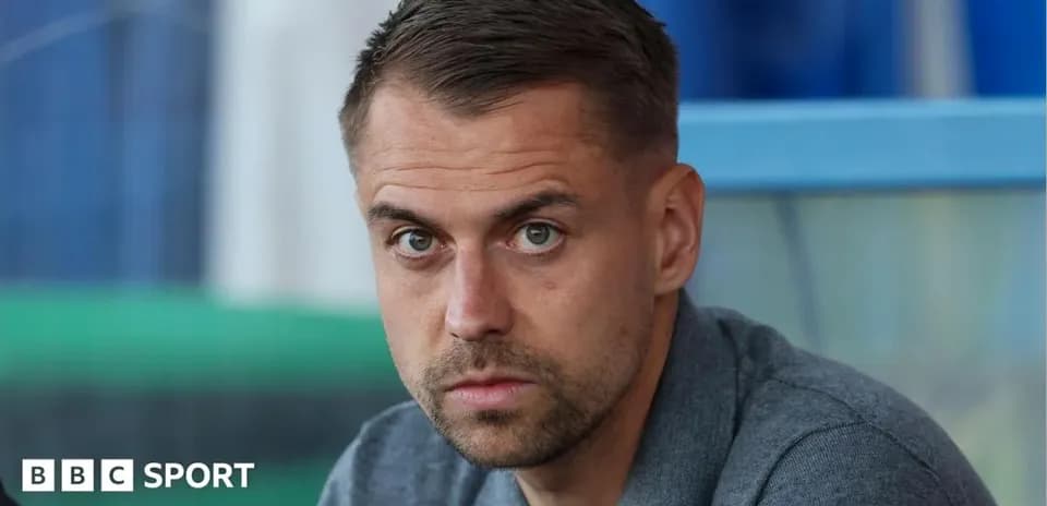 Hombre con mirada seria en un banquillo deportivo