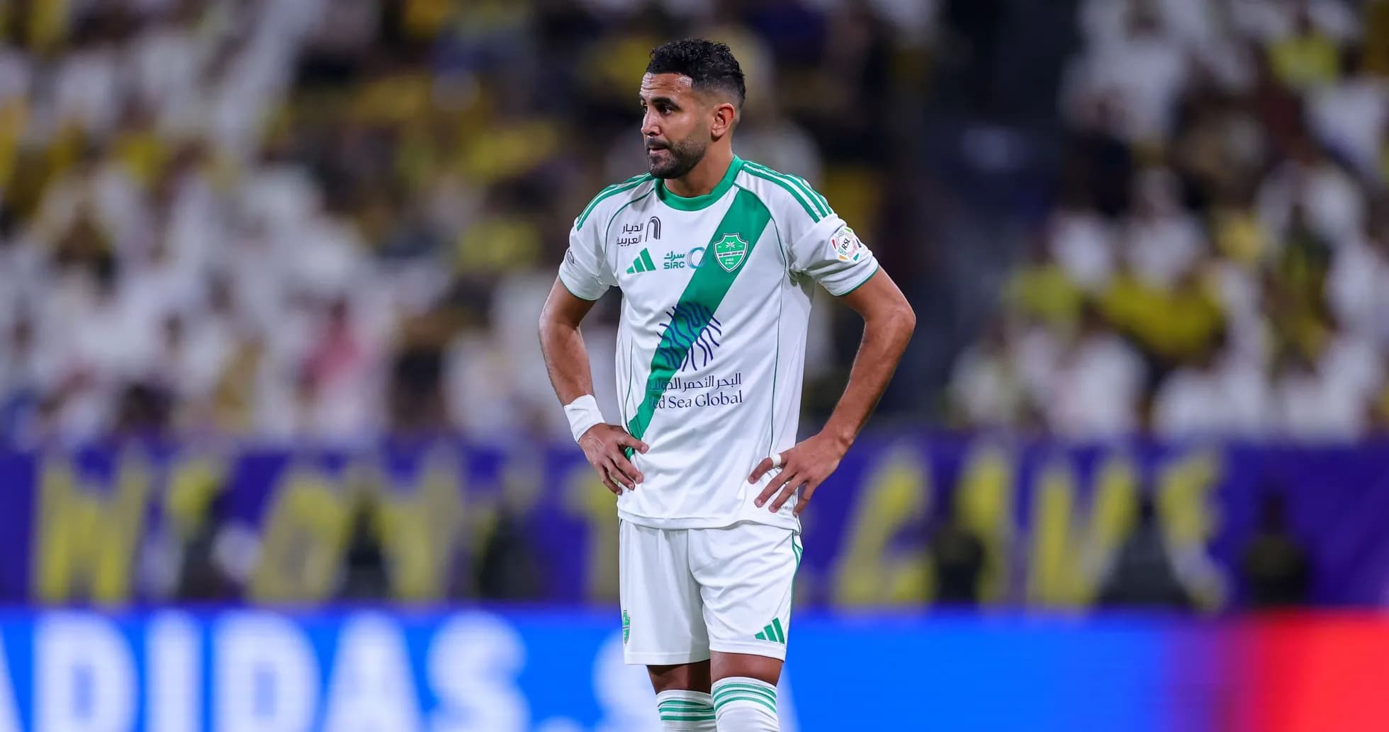 Jugador de fútbol con camiseta blanca y verde en el campo