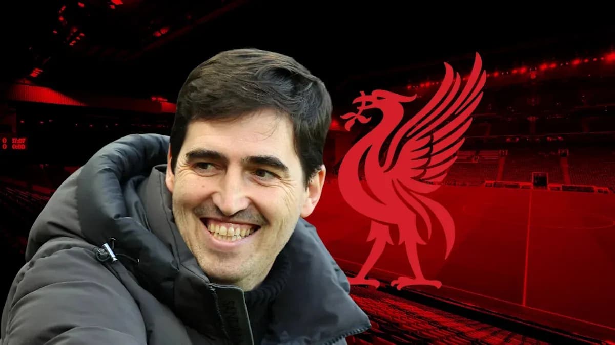 Entrenador sonriente frente al logo de Liverpool