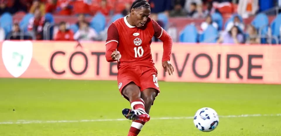 Jugador de Canadá pateando un balón en partido