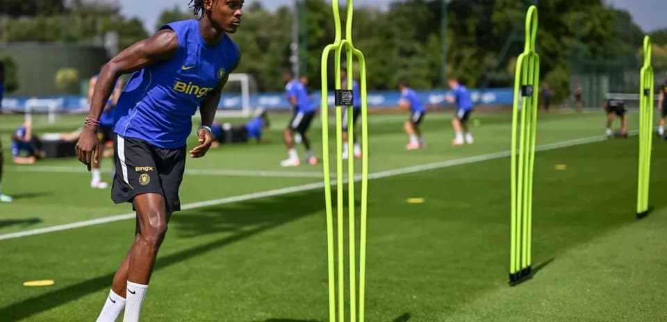 Jugador entrenando con conos en campo de entrenamiento