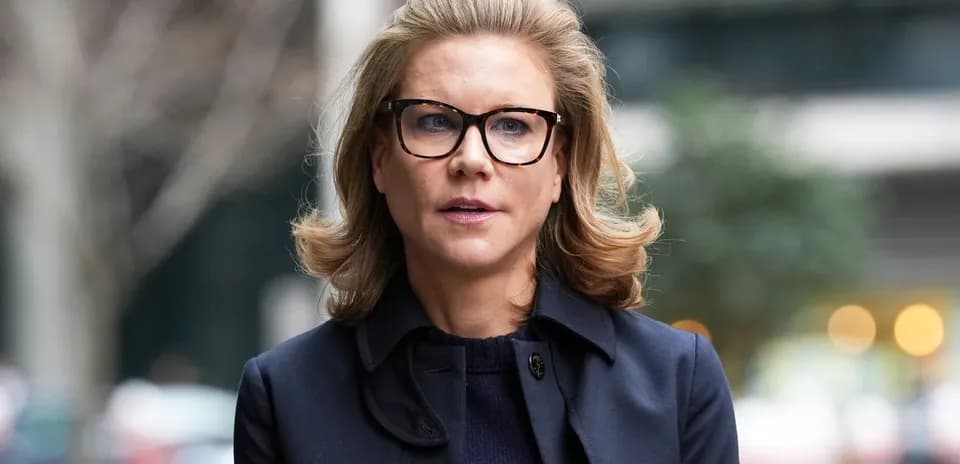 Mujer con gafas y abrigo caminando por la calle