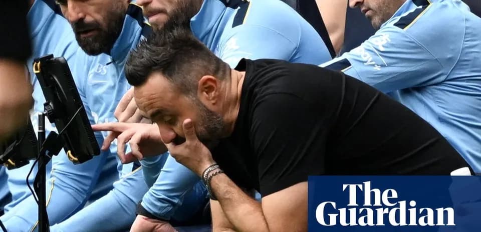 Entrenador preocupado viendo el partido desde el banquillo
