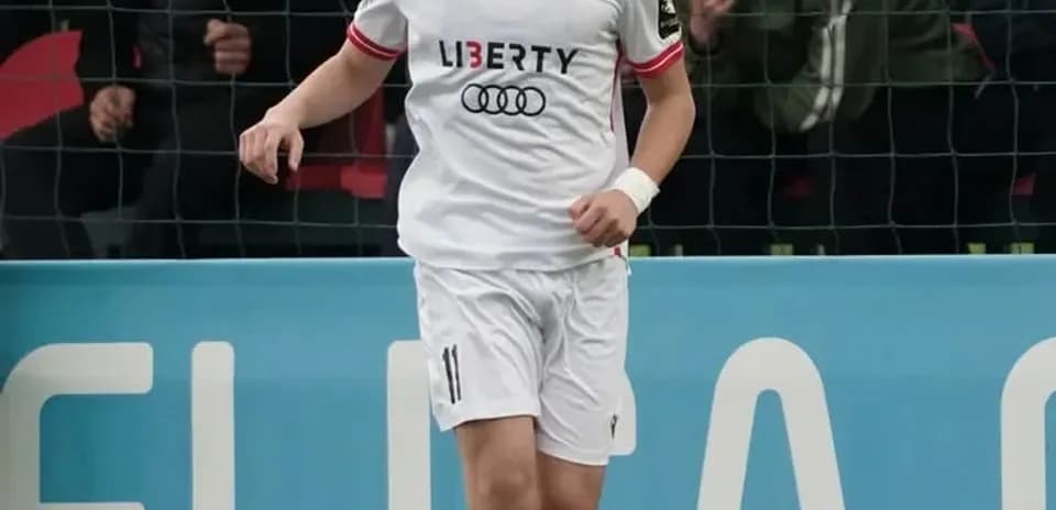 Jugador con balón en campo de fútbol durante partido