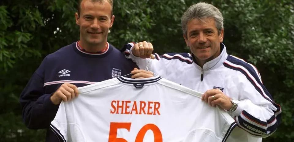 Alan Shearer y entrenador mostrando camiseta de Inglaterra