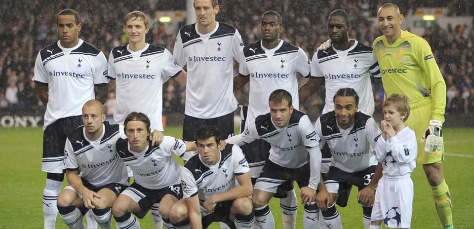 Equipo de Tottenham posando con un niño en el campo