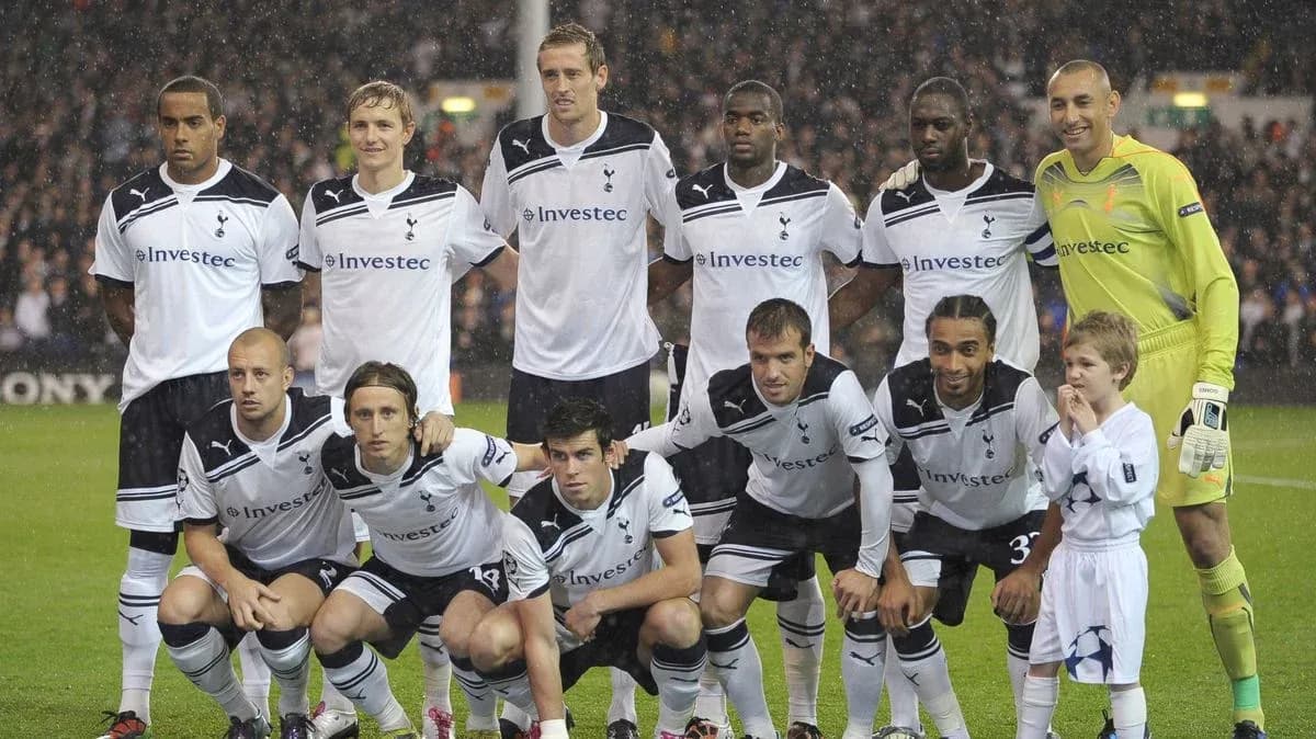 Equipo de Tottenham posando con un niño en el campo