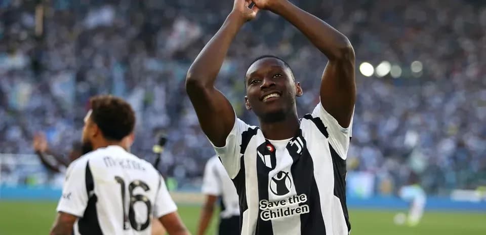 Jugador celebrando en el campo con afición de fondo