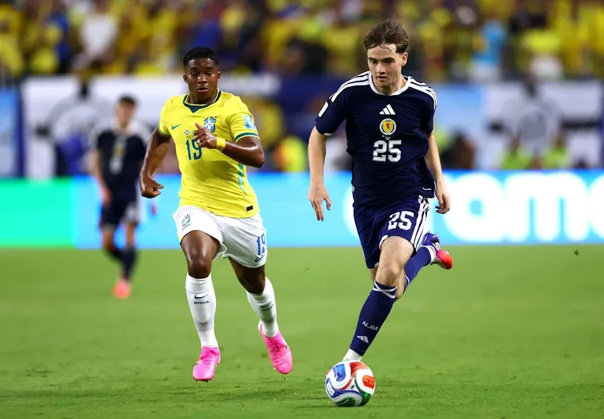 Jugador de Japón corriendo con balón, Brasil persiguiéndolo