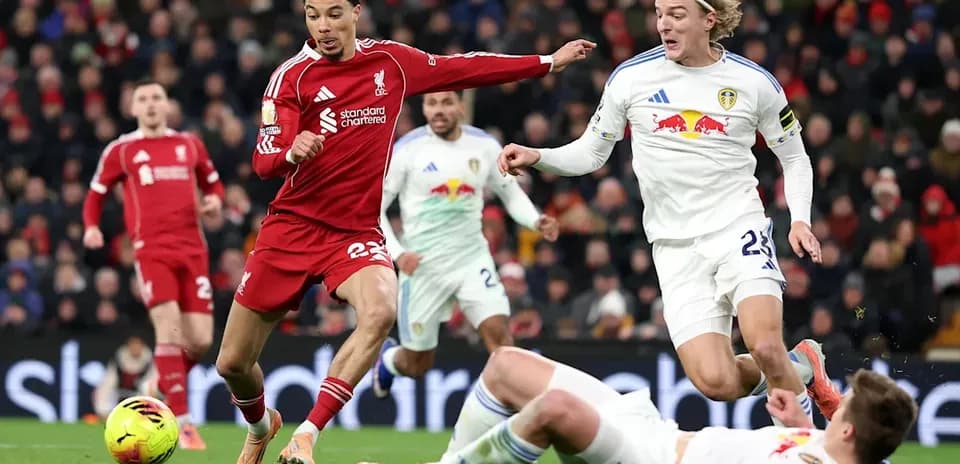Jugador de Liverpool driblando frente a oponentes de Leeds