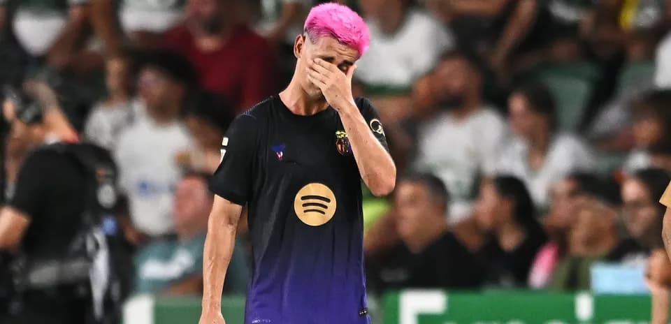 Jugador con cabello rosa caminando con la mano en la cara