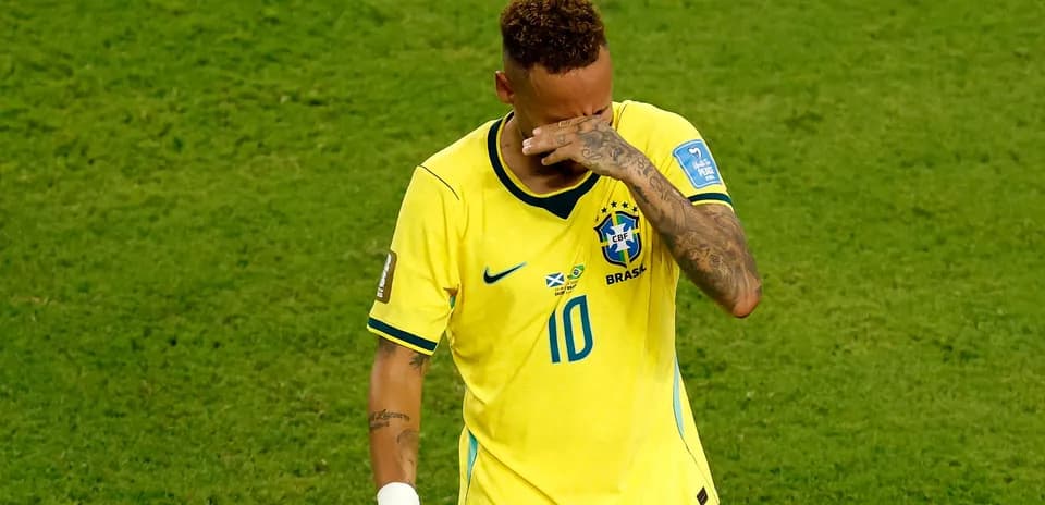 Jugador de Brasil se cubre la cara en el campo