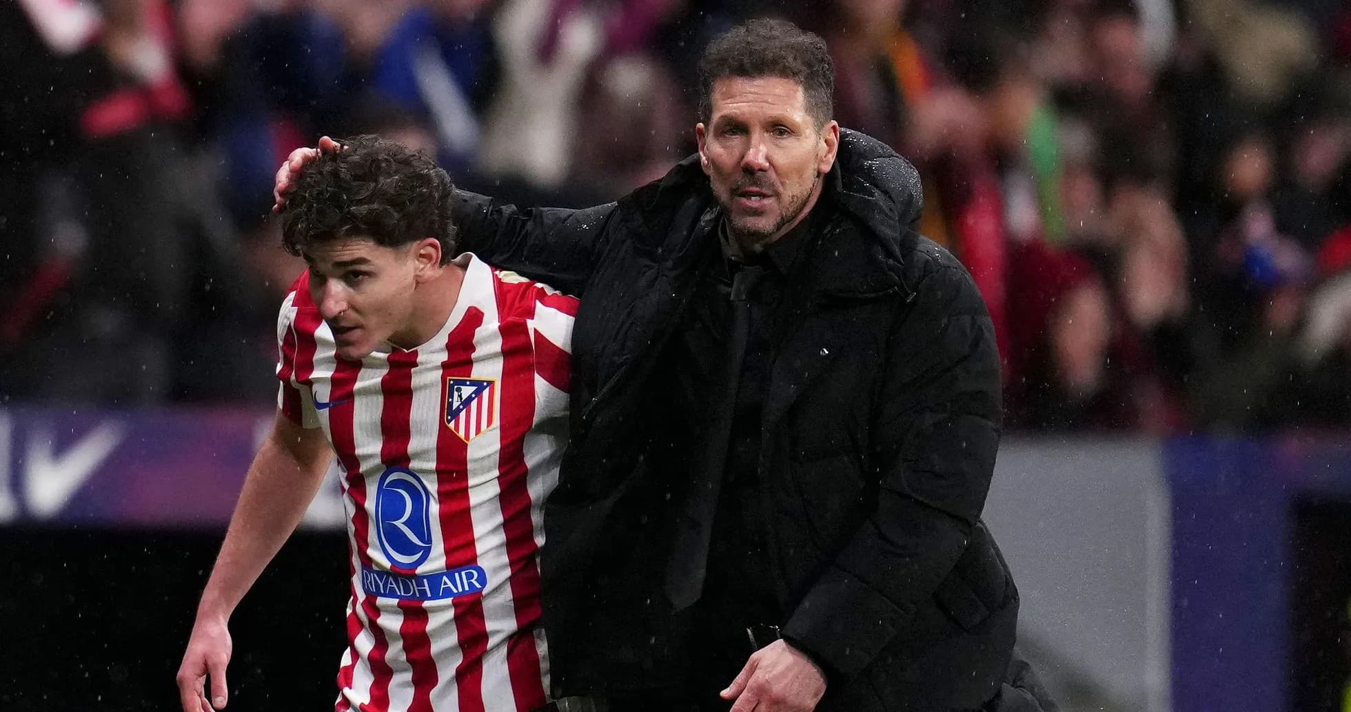 Entrenador guiando a jugador del Atlético de Madrid