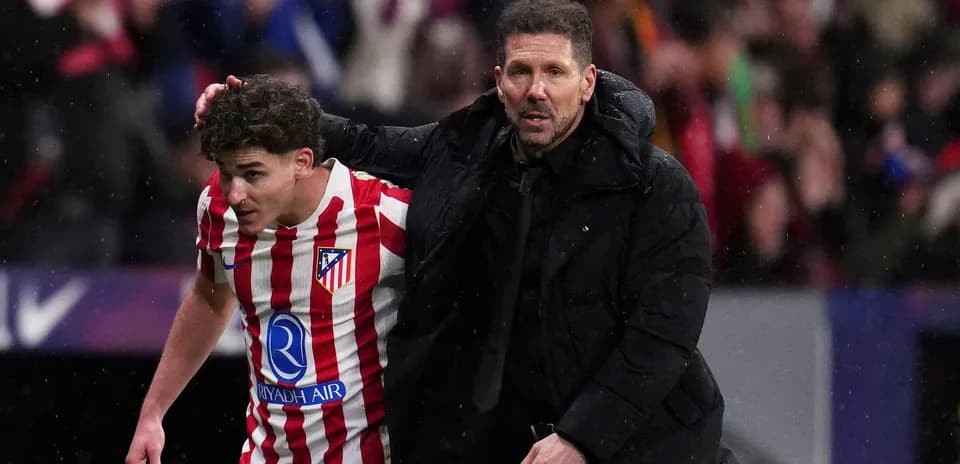 Entrenador guiando a jugador del Atlético de Madrid