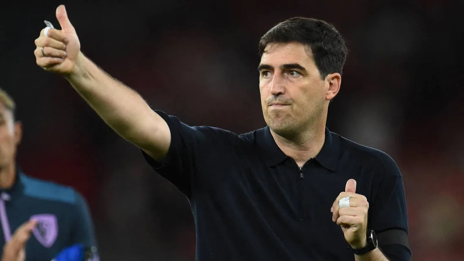 Entrenador mostrando pulgar arriba tras partido