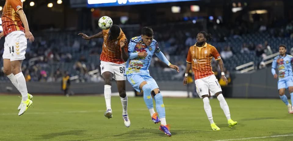 Jugador cabeceando el balón en el partido