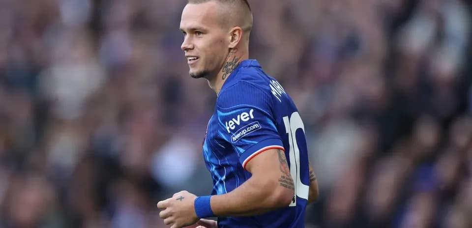 Jugador sonriendo con camiseta azul durante el partido