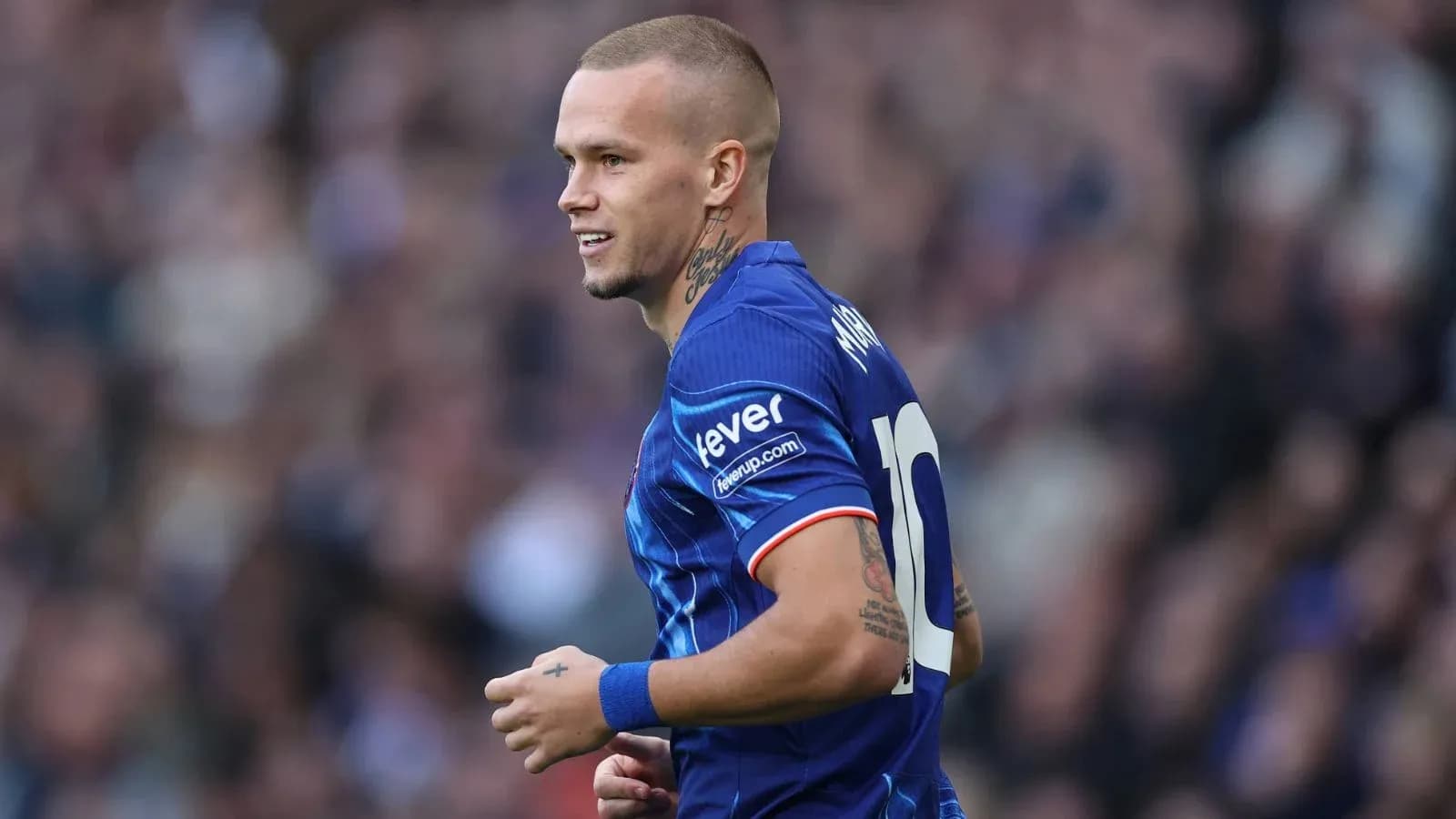 Jugador sonriendo con camiseta azul durante el partido