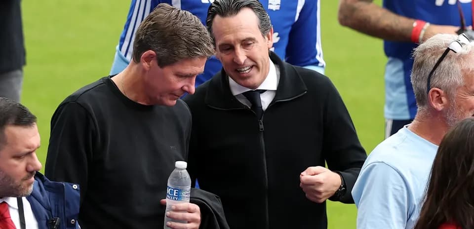 Dos entrenadores conversando en el campo de fútbol