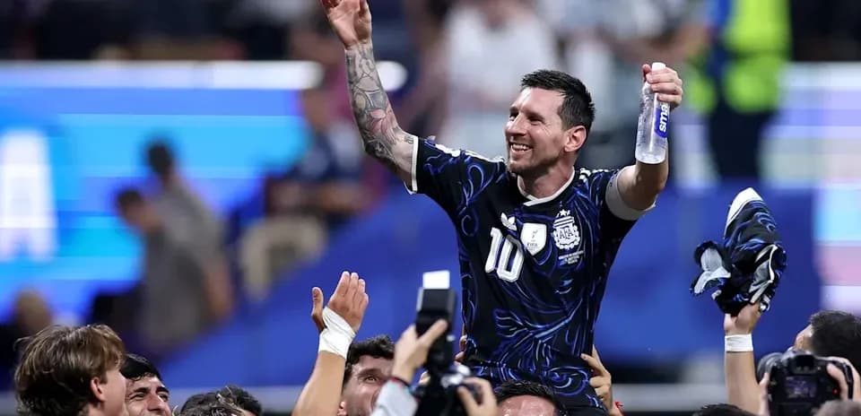 Lionel Messi siendo levantado por sus compañeros de equipo
