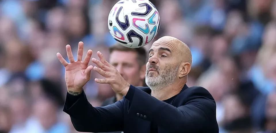 Entrenador intentando atrapar balón durante el partido