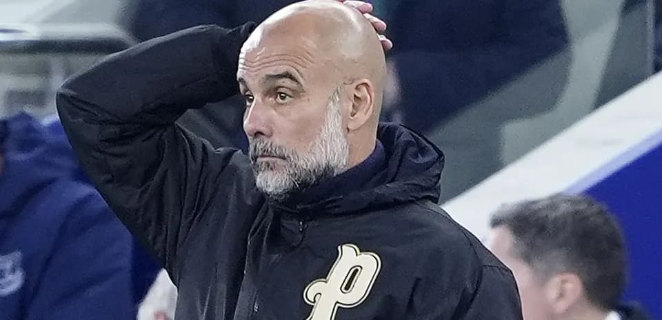 Entrenador con chaqueta negra en el banquillo