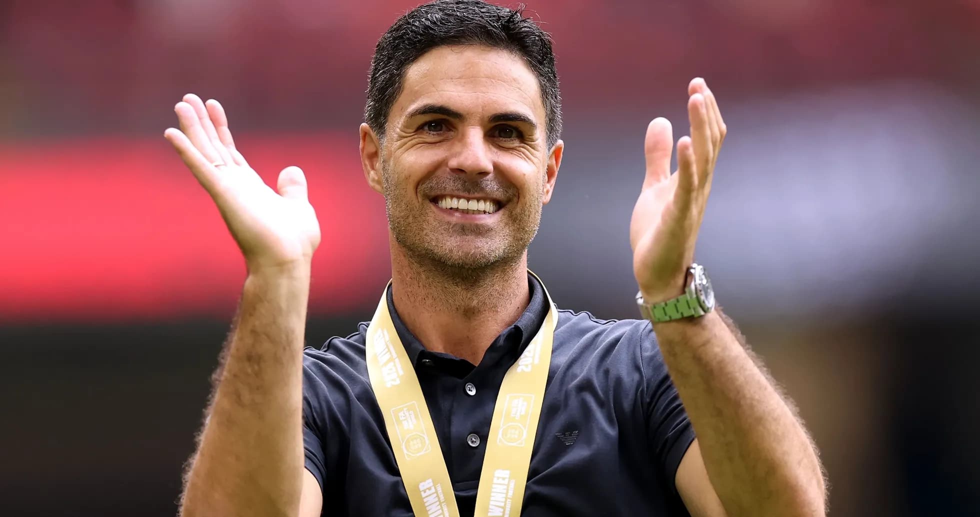 Entrenador aplaudiendo con medalla de ganador
