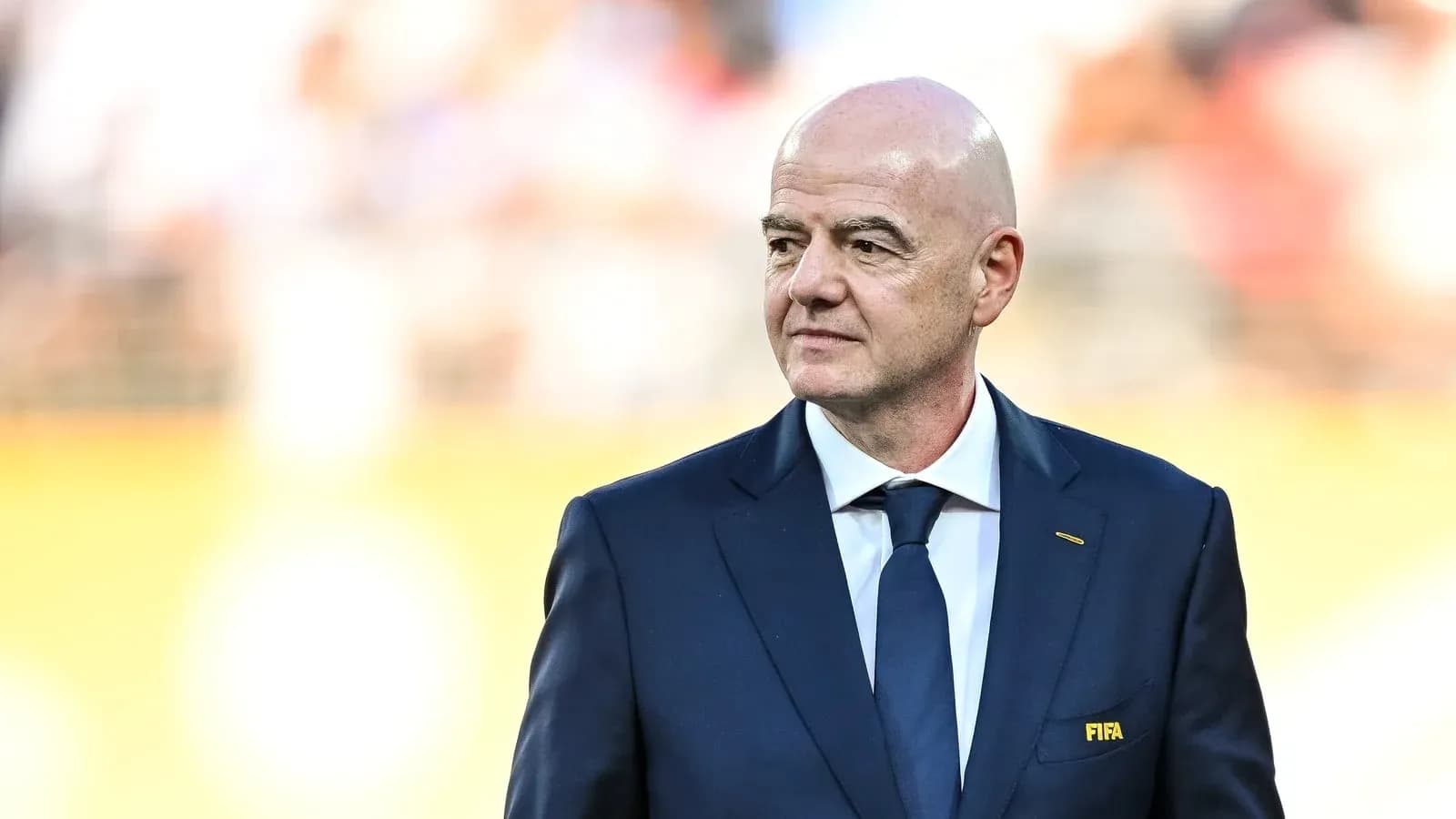 Hombre en traje con insignia de FIFA en evento