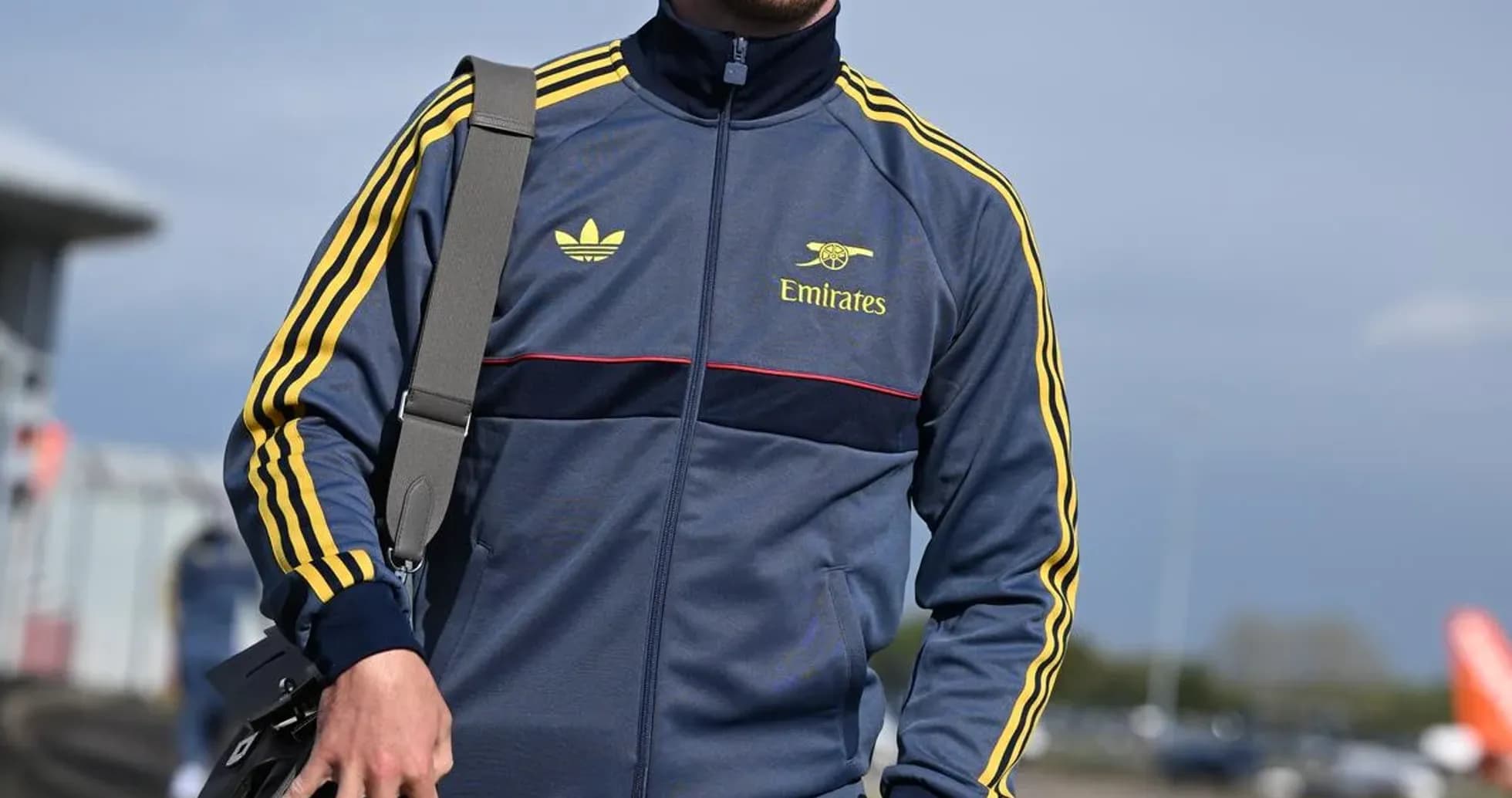 Jugador caminando con chándal y bolsa de mano