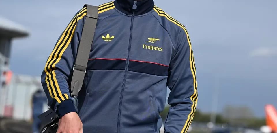 Jugador caminando con chándal y bolsa de mano