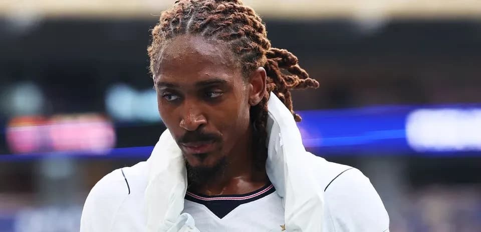 Jugador con trenzas caminando por el campo