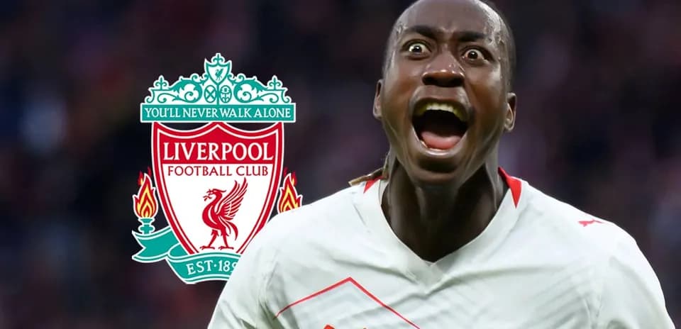 Jugador celebrando con el escudo de Liverpool de fondo