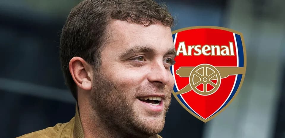Persona sonriendo con el escudo de Arsenal de fondo
