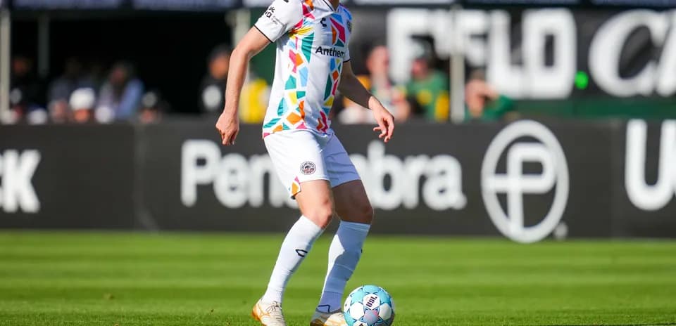 Jugador con balón en partido de fútbol