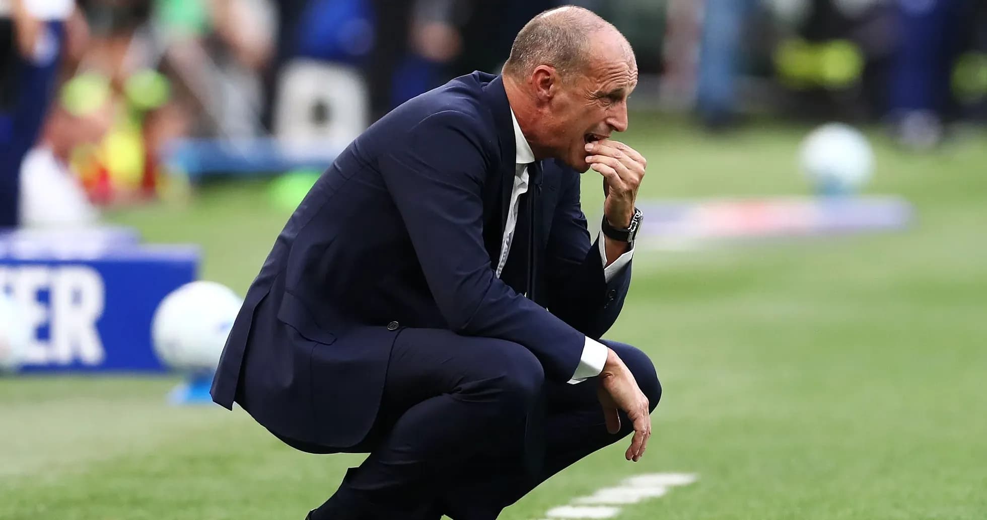 Entrenador agachado durante un partido de fútbol